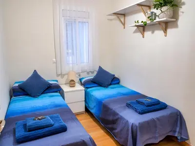 two beds in a room with blue sheets at Apartment PICNIC SANTS in Barcelona