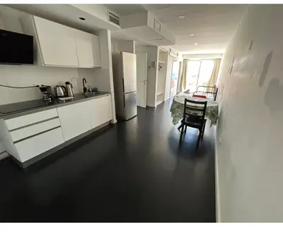 a kitchen with a table and a refrigerator at HUG HOTEL2022 in El Carrer del Canonge
