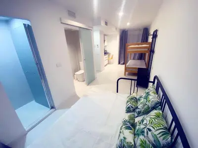 a living room with a couch and a bedroom at HUG HOTEL2022 in El Carrer del Canonge