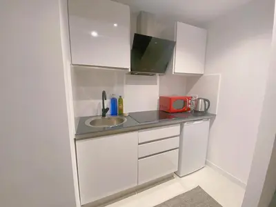 a small kitchen with a sink and a red microwave at HUG HOTEL2022 in El Carrer del Canonge