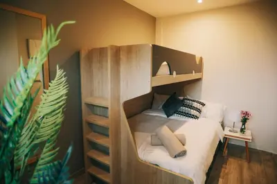 a bedroom with a bunk bed with a white bedsheet at RCE Apartments Calella, brand new next to the beach. in Calella