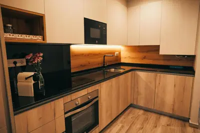 a kitchen with wooden cabinets and a sink at RCE Apartments Calella, brand new next to the beach. in Calella
