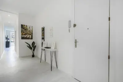 a white room with a table and posters on the wall at The White Flats Sant Antoni in Barcelona