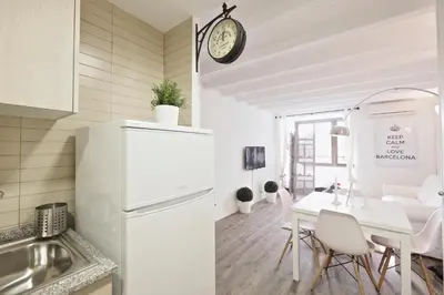 a kitchen and a dining room with a white refrigerator at The White Flats Sant Antoni in Barcelona