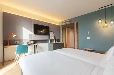 a bedroom with a white bed and a blue wall at Holiday Inn Barcelona - Sant Cugat by IHG in Sant Cugat del Vallès