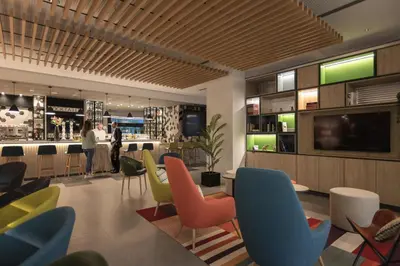 a restaurant with colorful chairs and a bar at Holiday Inn Barcelona - Sant Cugat by IHG in Sant Cugat del Vallès