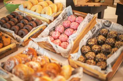a display of different types of donuts on a table at Holiday Inn Barcelona - Sant Cugat by IHG in Sant Cugat del Vallès