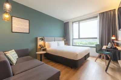 a hotel room with a bed and a couch at Holiday Inn Barcelona - Sant Cugat by IHG in Sant Cugat del Vallès