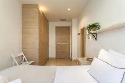 a bedroom with a white bed and a wooden door at Casa 20 minutos de Barcelona y WIFI alta capacidad in Sant Cugat del Vallès