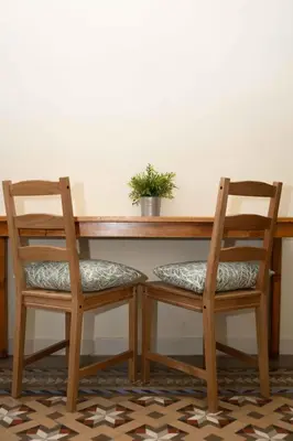 two chairs sitting at a wooden table with a plant at 360 Hostel Borne in Barcelona