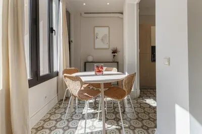 a dining room with a white table and chairs at Weflating Sant Antoni Market in Barcelona