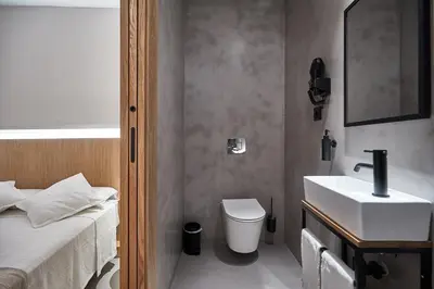 a bathroom with a sink and a toilet and a bed at Ella Hostel Ramblas in Barcelona