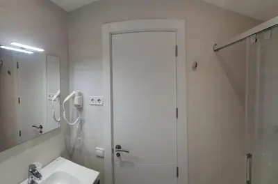 a white bathroom with a shower and a sink at Barcelona, Apartamento de 2 habitaciones. in Hospitalet de Llobregat