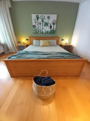 a bedroom with a bed and a basket on the floor at Bright with pool near the beach and Barcelona by train in Masnou