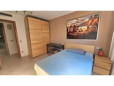 a bedroom with a bed and a painting on the wall at Apartament Calella in Calella