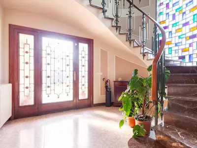 a hallway with a staircase and a door with a plant at Cal Kim in Martorell