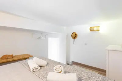 a white room with a bed with towels on it at Stay U-nique Apartments Travessera II in Barcelona