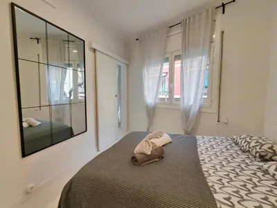 a bedroom with a large bed and a large mirror at Family apartment close to Parc Güell in Barcelona