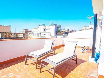 two chairs on a balcony with a view of a city at Elite Bonaire Penthouse by Hello Homes Sitges in Sitges