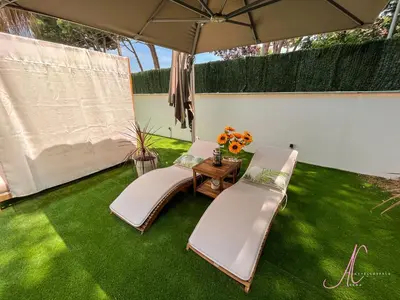 two chairs and an umbrella on a lawn at Arena Castelldefels in Castelldefels