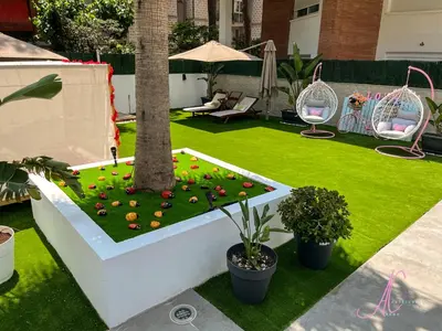 a garden with a palm tree and flowers on the grass at Arena Castelldefels in Castelldefels