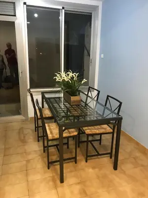 a glass table and chairs with a potted plant on it at Piso céntrico con Parking a 20min de Barcelona in Terrassa
