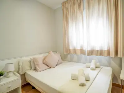 a white bed in a room with a window at Golden Sands by Hello Homes Sitges in Sitges