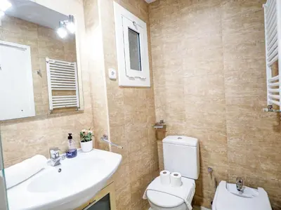 a bathroom with a sink and a toilet and a mirror at Golden Sands by Hello Homes Sitges in Sitges