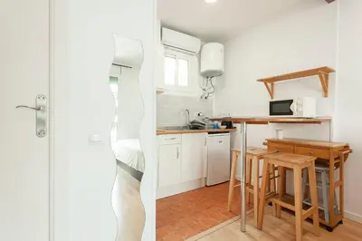 a kitchen with white cabinets and a small table at SAGRADA FAMILIA APARTAMENT in Barcelona