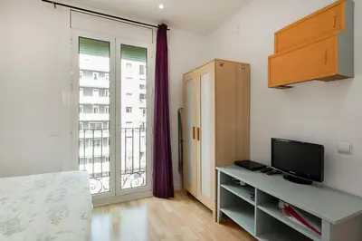 a room with a tv and a bed and a window at SAGRADA FAMILIA APARTAMENT in Barcelona