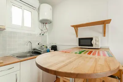 a kitchen with a wooden table with a microwave on it at SAGRADA FAMILIA APARTAMENT in Barcelona