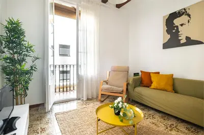 a living room with a green couch and a yellow table at CENTRIC APARTMENT GAUDI in Barcelona