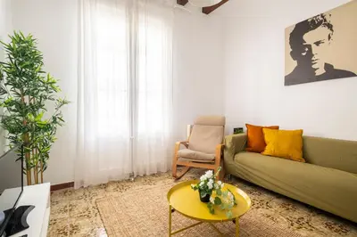 a living room with a green couch and a table at CENTRIC APARTMENT GAUDI in Barcelona