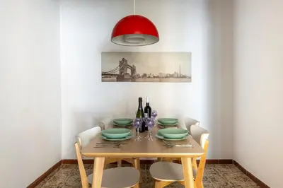 a dining room table with a red lamp and wine bottles at CENTRIC APARTMENT GAUDI in Barcelona