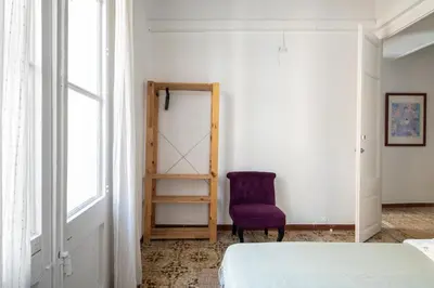 a bedroom with a purple chair and a mirror at CENTRIC APARTMENT GAUDI in Barcelona