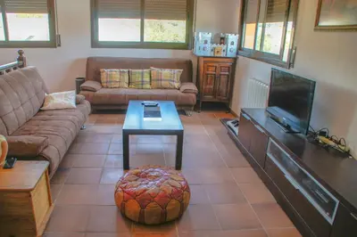 a living room with a couch and a tv at Casa Martina in Cardedeu