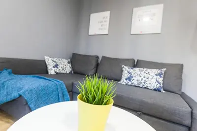 a living room with a couch and a table with a plant at Be Barcelona Plaza Catalunya in Barcelona