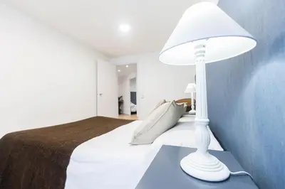 a white lamp sitting on a blue table next to a bed at Be Barcelona Plaza Catalunya in Barcelona
