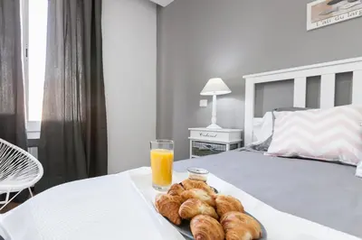 a tray of pastries and a glass of orange juice on a bed at Be Barcelona Eixample Arco del Triunfo in Barcelona