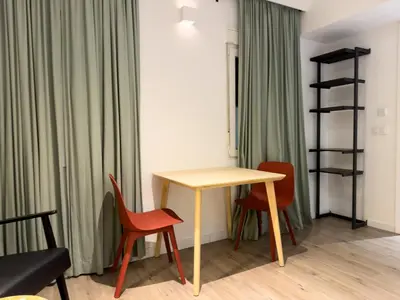 a table and chairs in a room with green curtains at Casp Green House in Barcelona