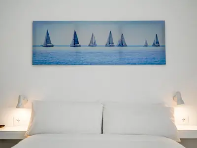 a bedroom with a bed with sailboats in the water at Sitges with pool near beach by Hello Homes Sitges in Sitges