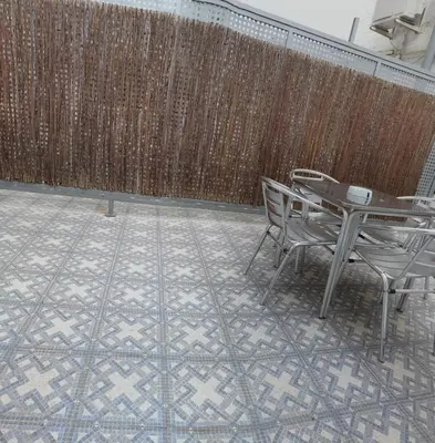 a table and chairs in front of a wooden fence at BARCELONA DUPLEX DE 3 HABITACIONES in Hospitalet de Llobregat