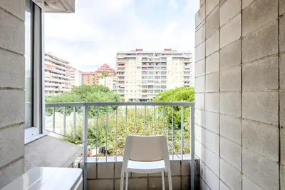 a white chair sitting on a balcony with a window at Impresionante Apartamento delante del Mar in Vilassar de Mar