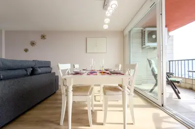 a white dining room with a white table and chairs at Impresionante Apartamento delante del Mar in Vilassar de Mar