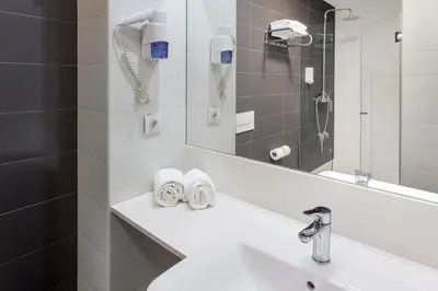 a bathroom with a sink and a mirror at B&B HOTEL Barcelona Viladecans in Viladecáns