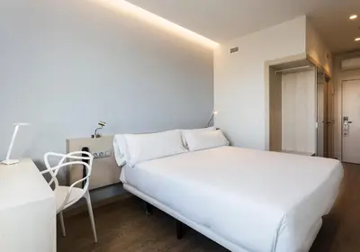 a small bedroom with a bed and a desk at B&B HOTEL Barcelona Viladecans in Viladecáns