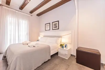 a white bedroom with a white bed and a window at Sweett - La Villarroel in Barcelona
