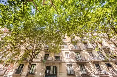 an apartment building with trees in front of it at Sweett - La Villarroel in Barcelona