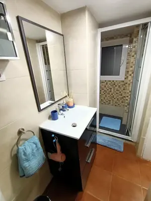 a bathroom with a sink and a shower with a mirror at COLORS FIRA GRAN VIA in Hospitalet de Llobregat