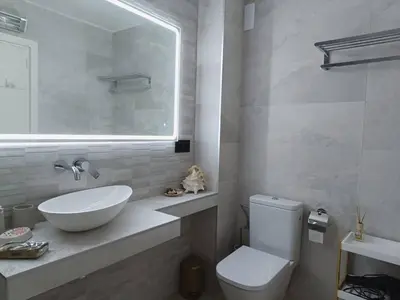 a bathroom with a sink and a toilet and a mirror at Elegante apt. p/4 pax a 1 min de la Playa con WiFI in Arenys de Mar